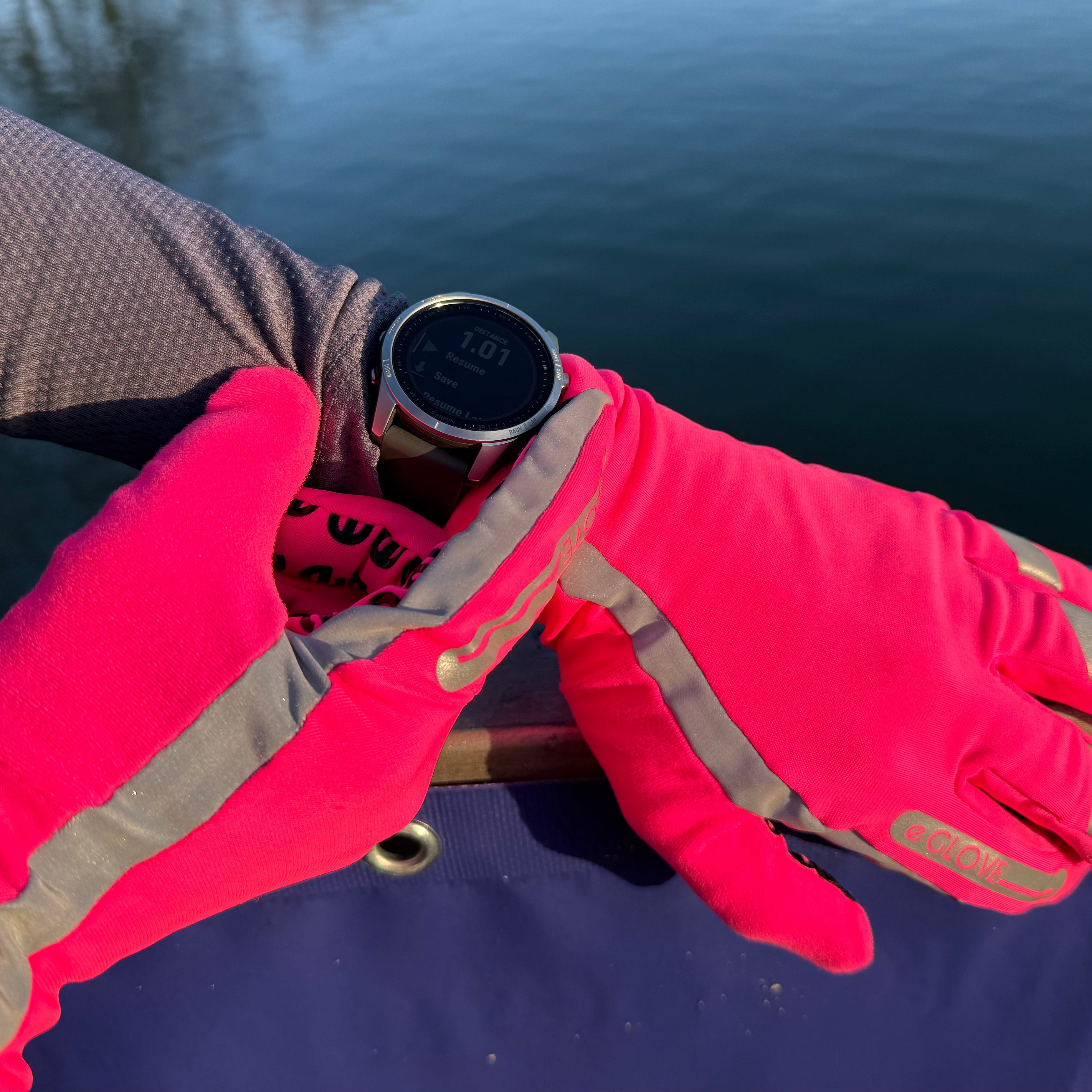Pink running gloves with hi viz elements demonstrating touchscreen use