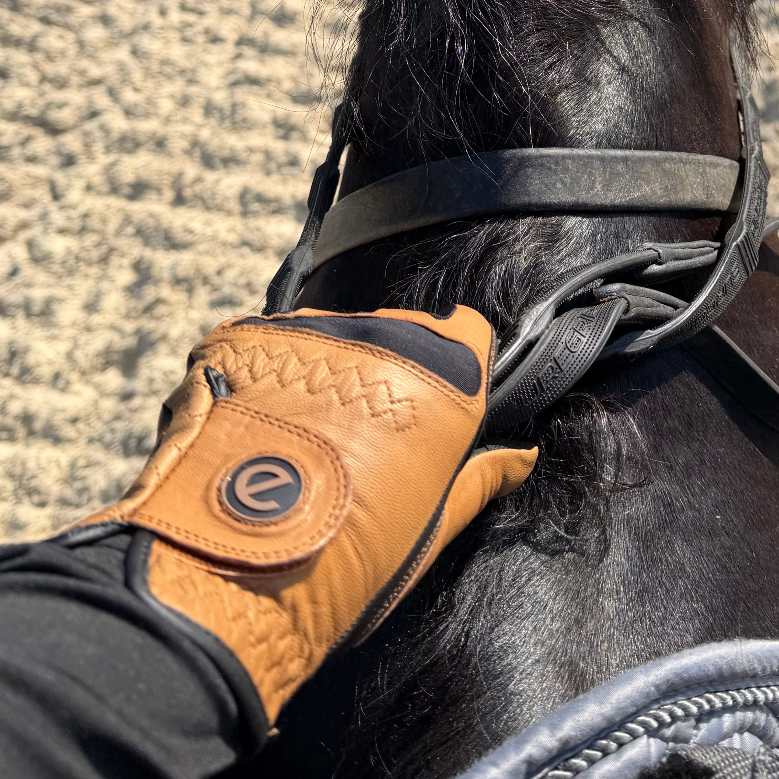eGLOVE Tan and Black Cabretta Leather touchscreen riding gloves holding horses reins